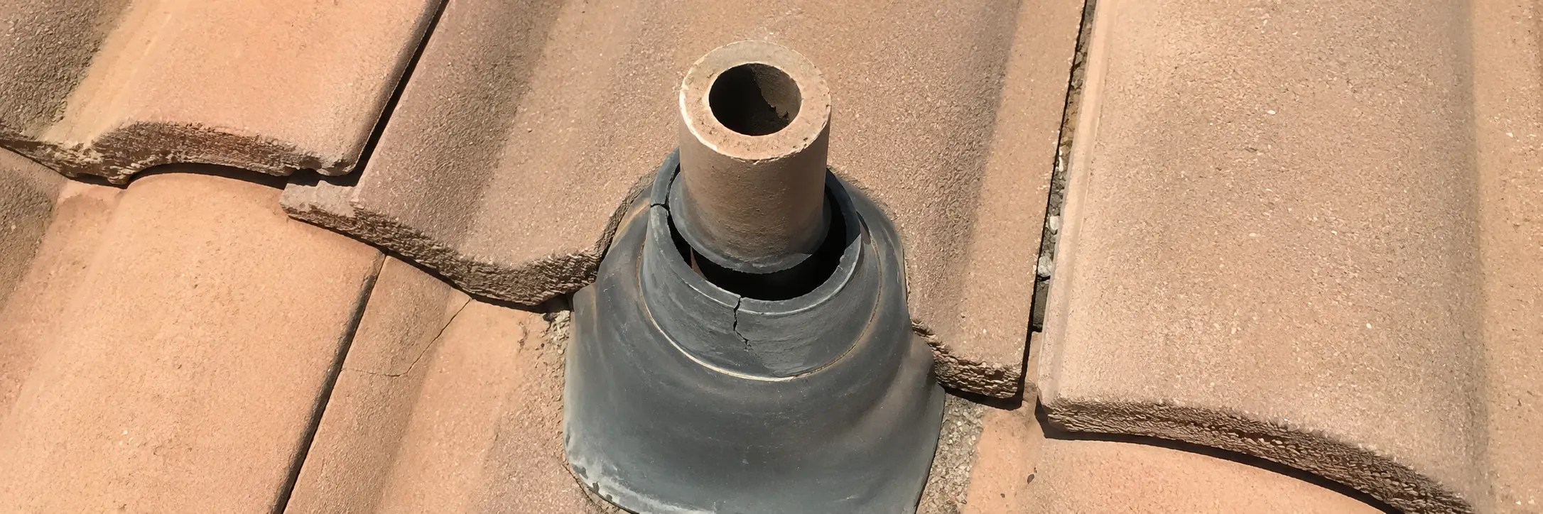 Cracked rubber pipe boot on a concrete tile roof in Tucson - the kind of isolated damage that calls for a repair, not a full replacement