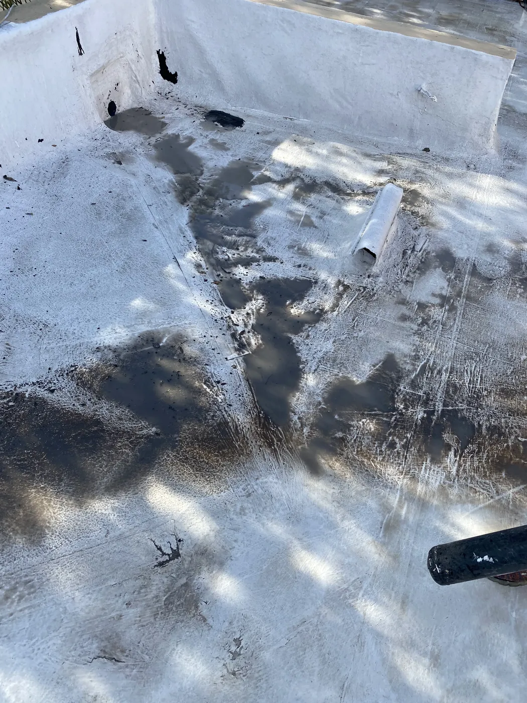 Severely deteriorated flat roof membrane with tears and holes on a Tucson building
