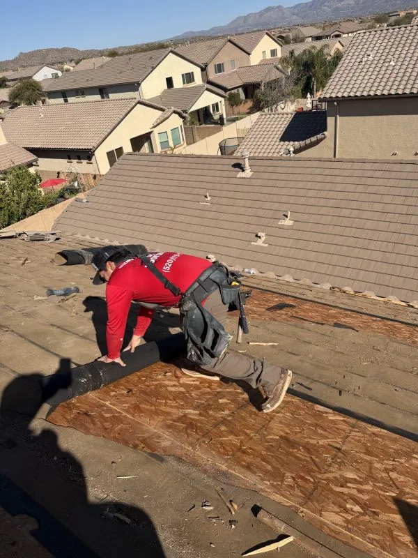 Roofer removing old tile roofing during tear-off in Tucson